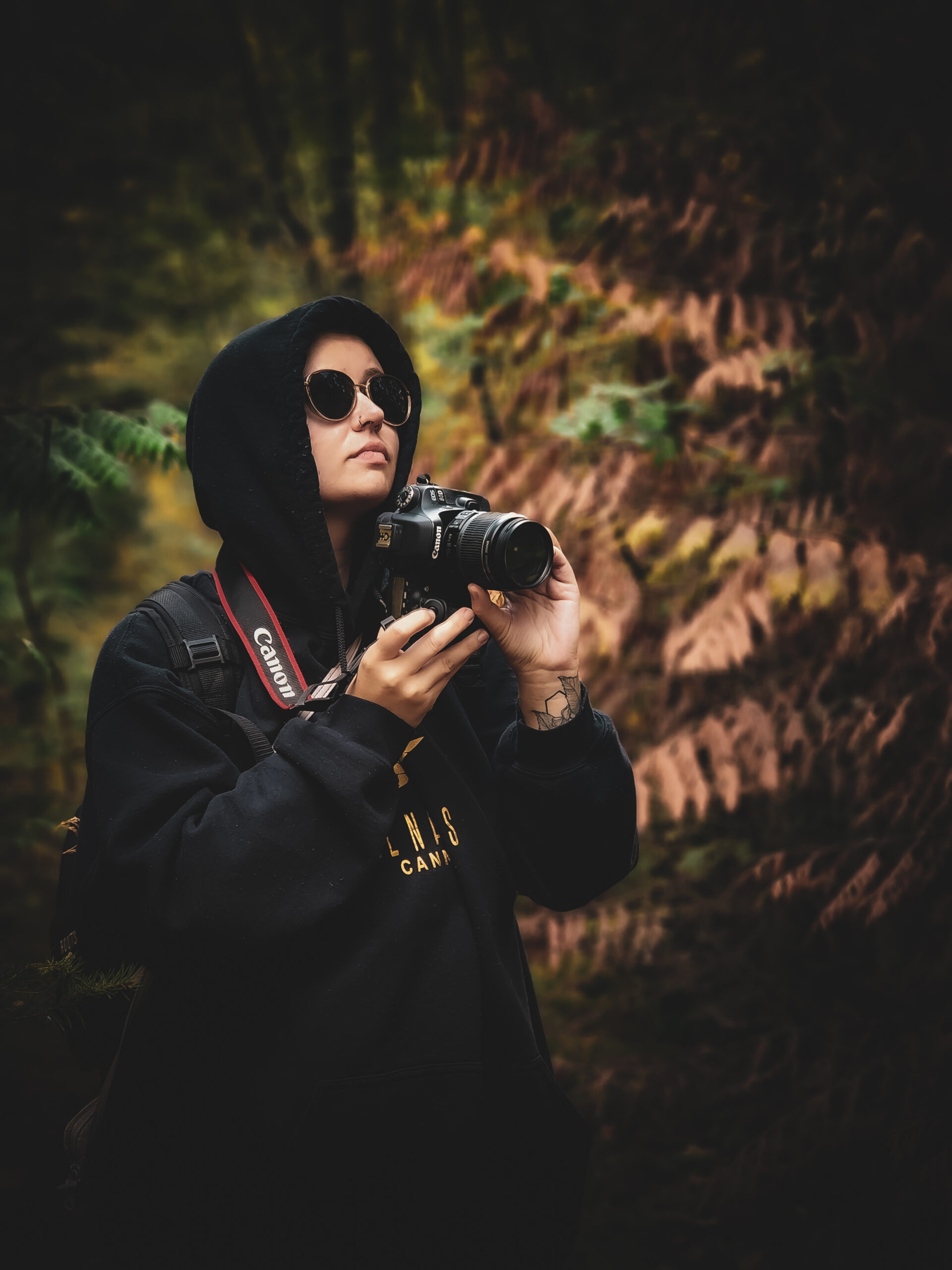 a picture of a person holding a camera in the woods